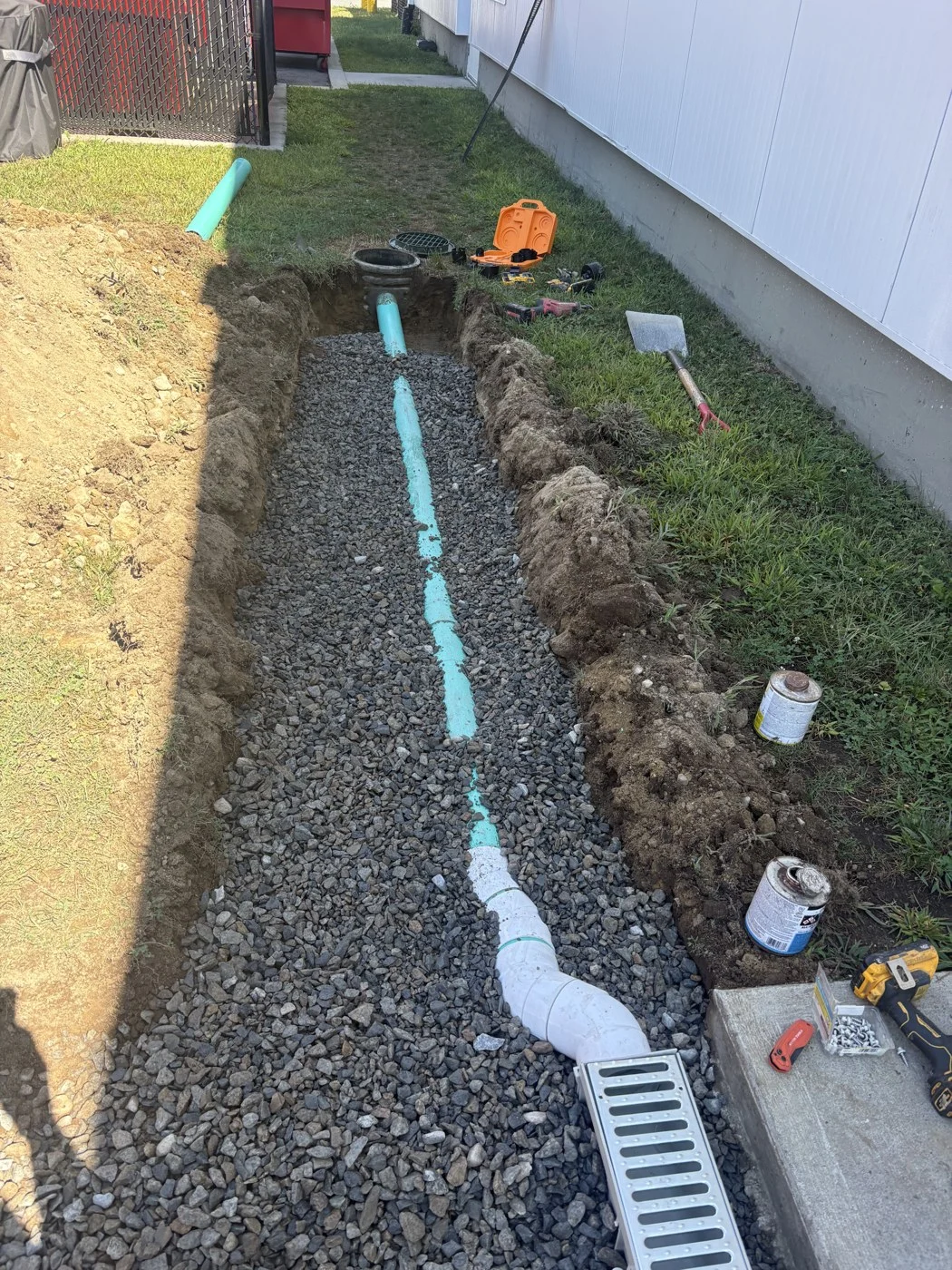 Drainage pipe and channel drain installation beside a building