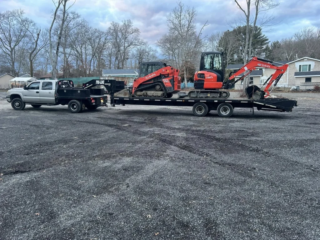 JP truck and trailer loaded with a Kubota excavator and compact track loader