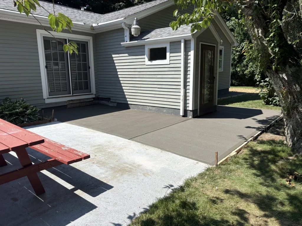 Finished residential patio surface beside a gray house