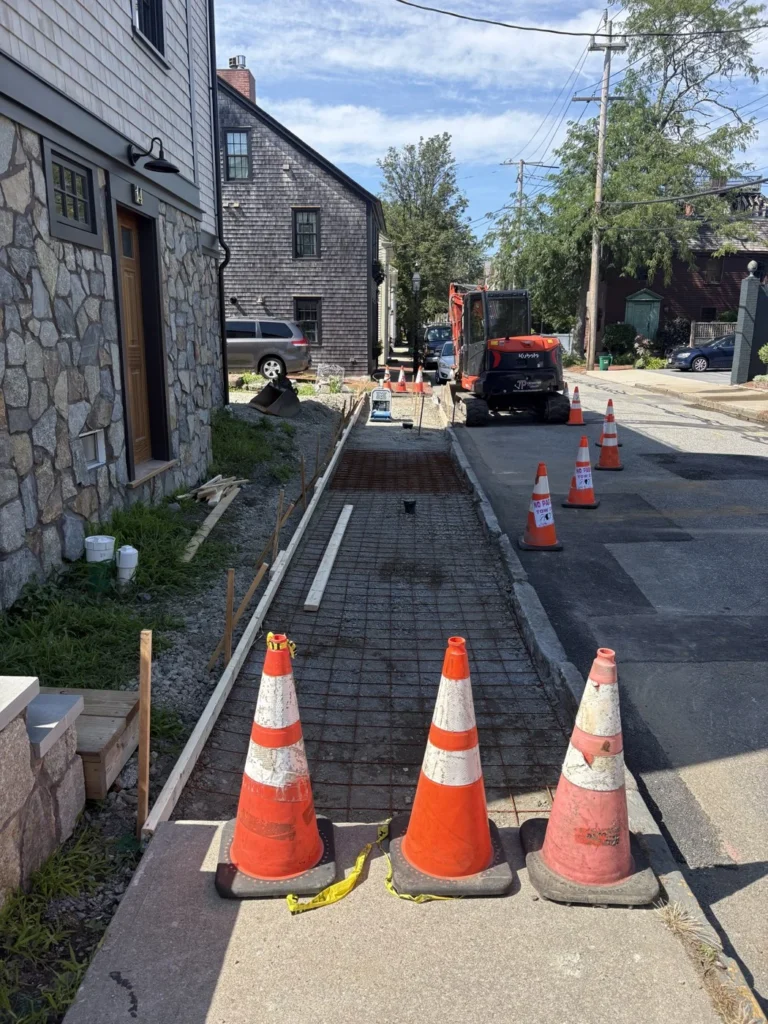 Sidewalk work in progress with equipment and safety cones