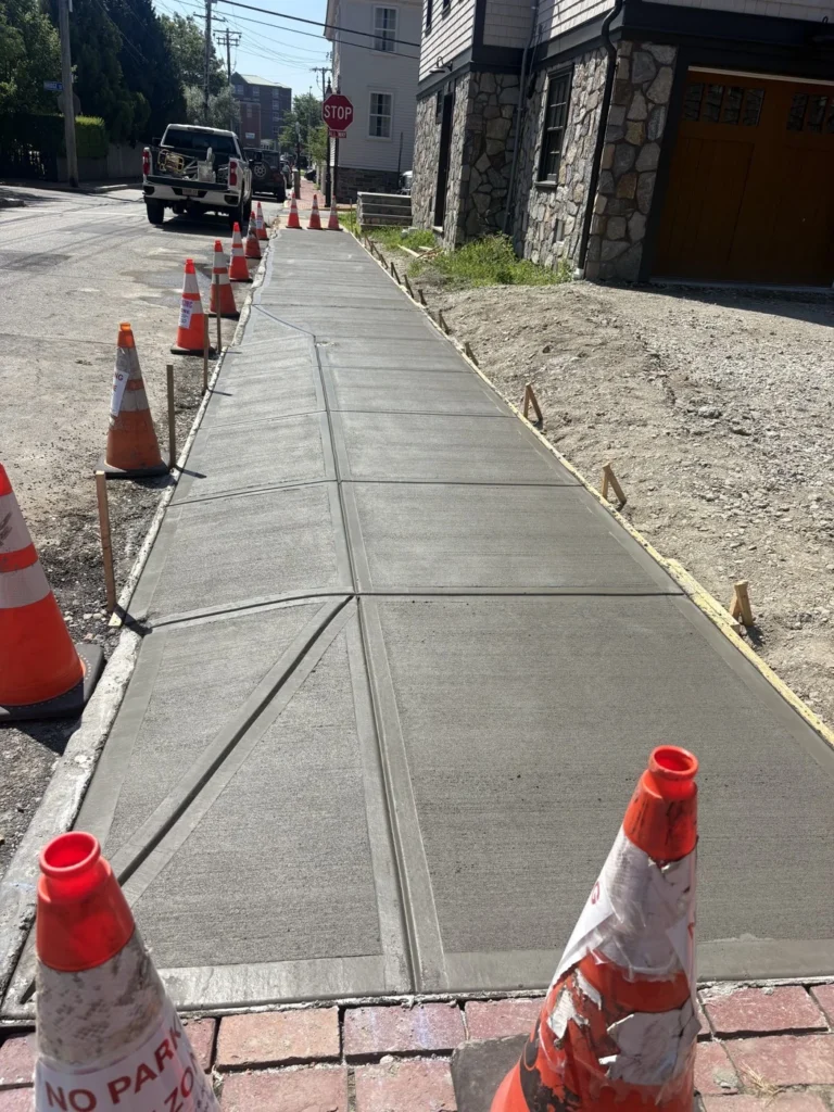 Completed sidewalk surface beside a stone building