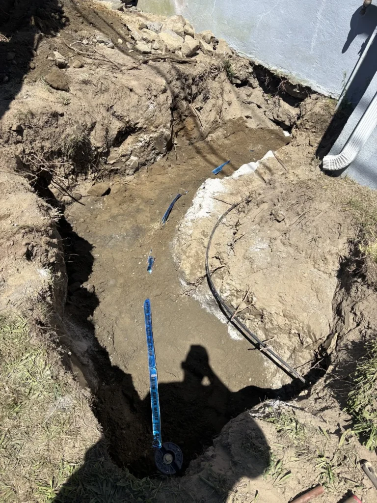Exposed utility pipe and fittings in an excavated trench