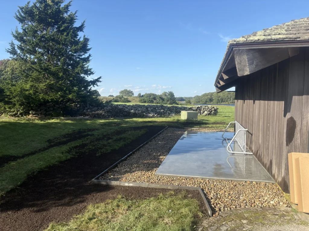 Finished stone edge and gravel surface beside a waterfront building