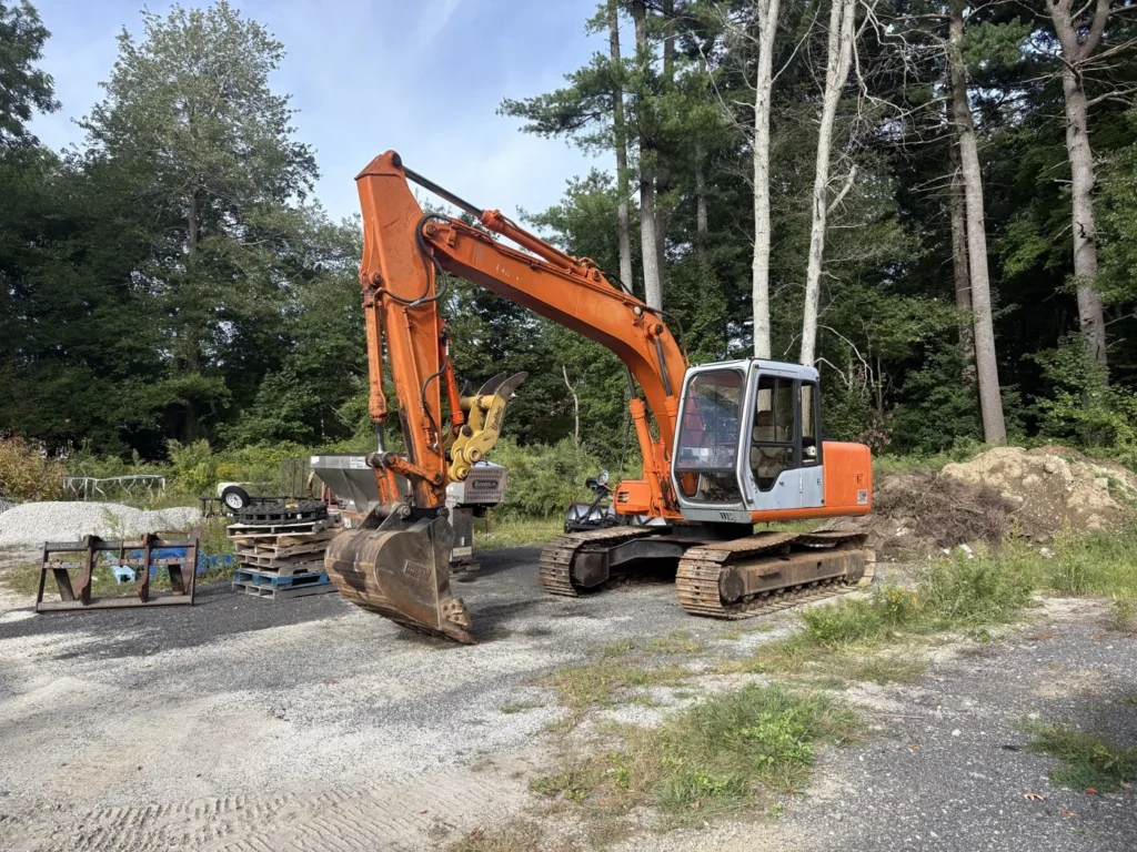 Excavator and bucket attachments at a wooded property