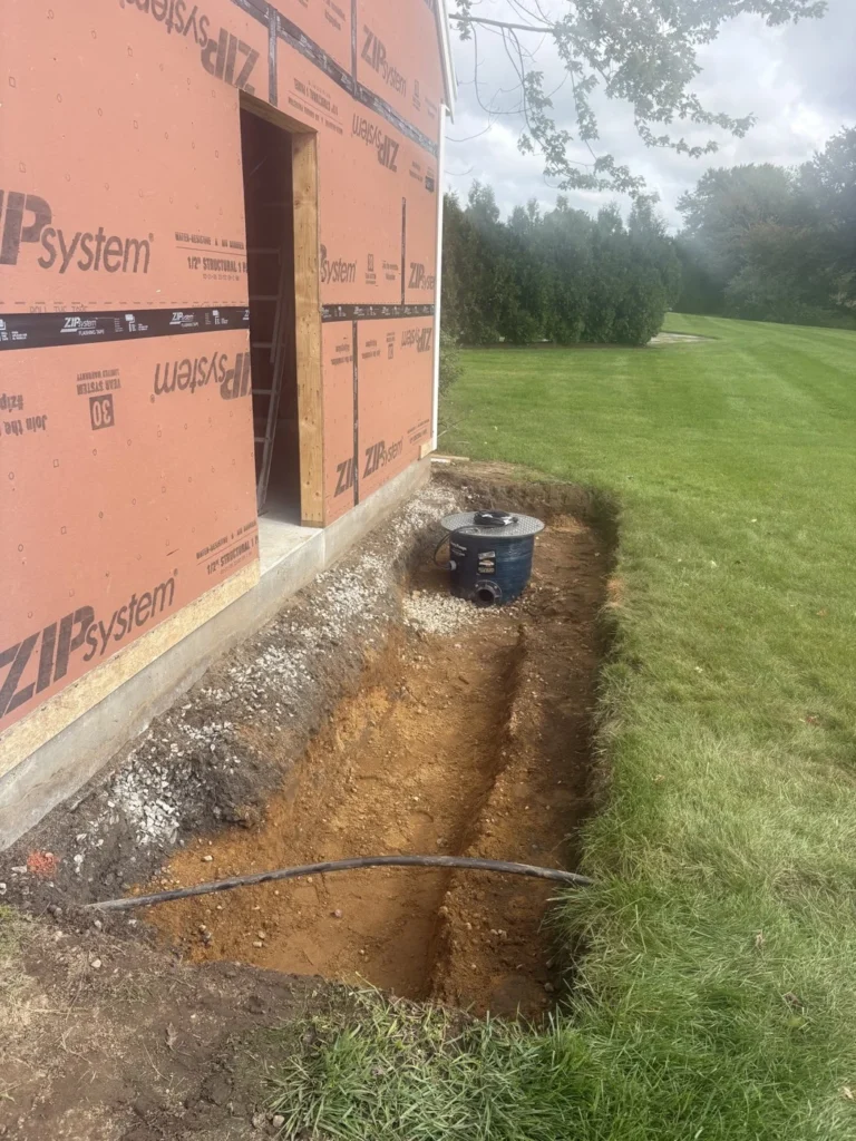 Underground tank riser and excavated utility area beside a building