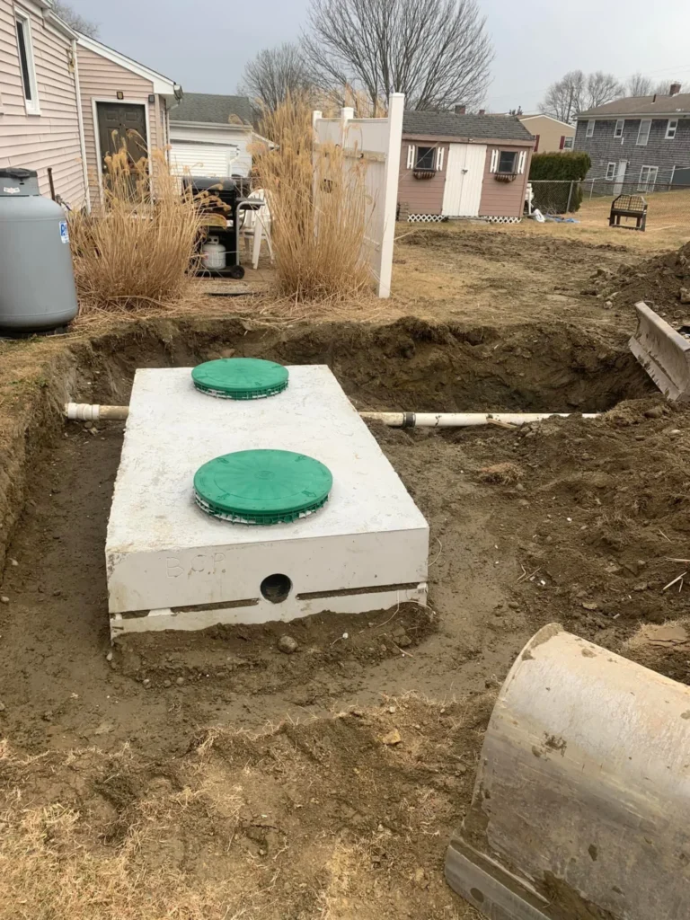 Concrete septic tank with green access covers during installation
