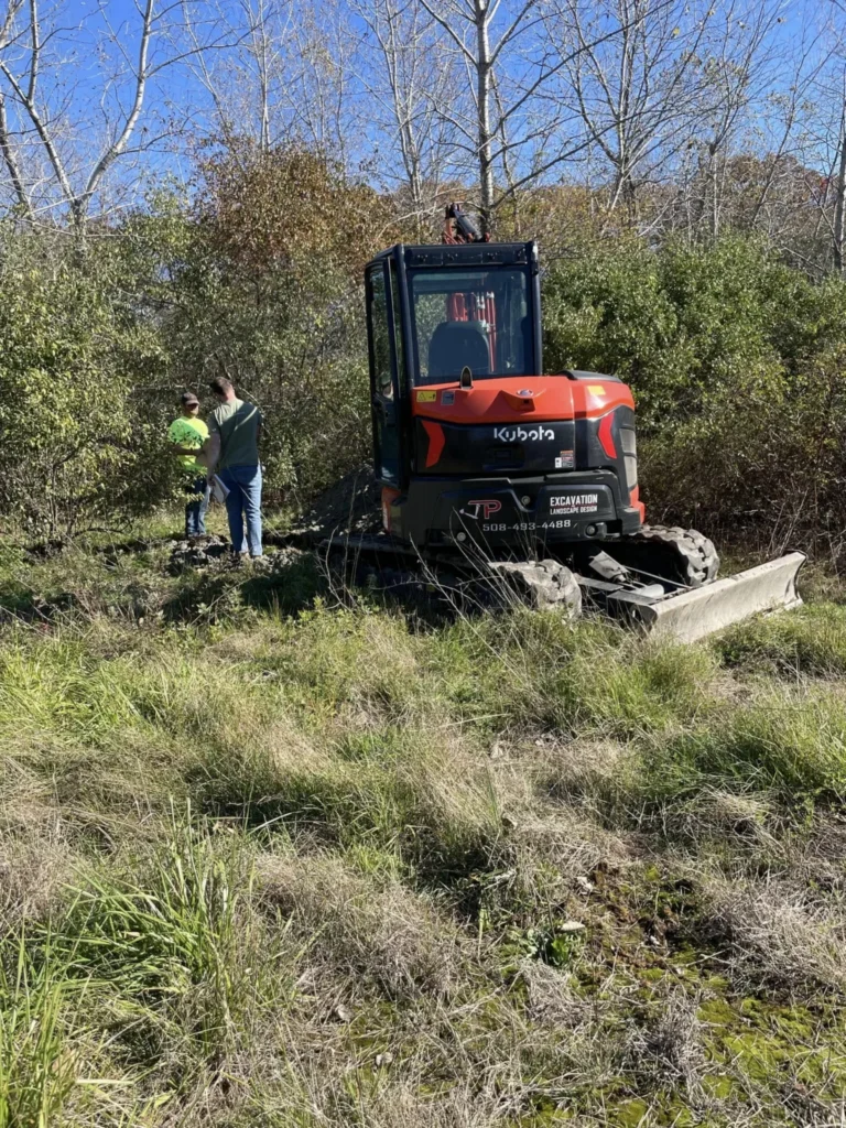 Compact excavator at a wooded property edge